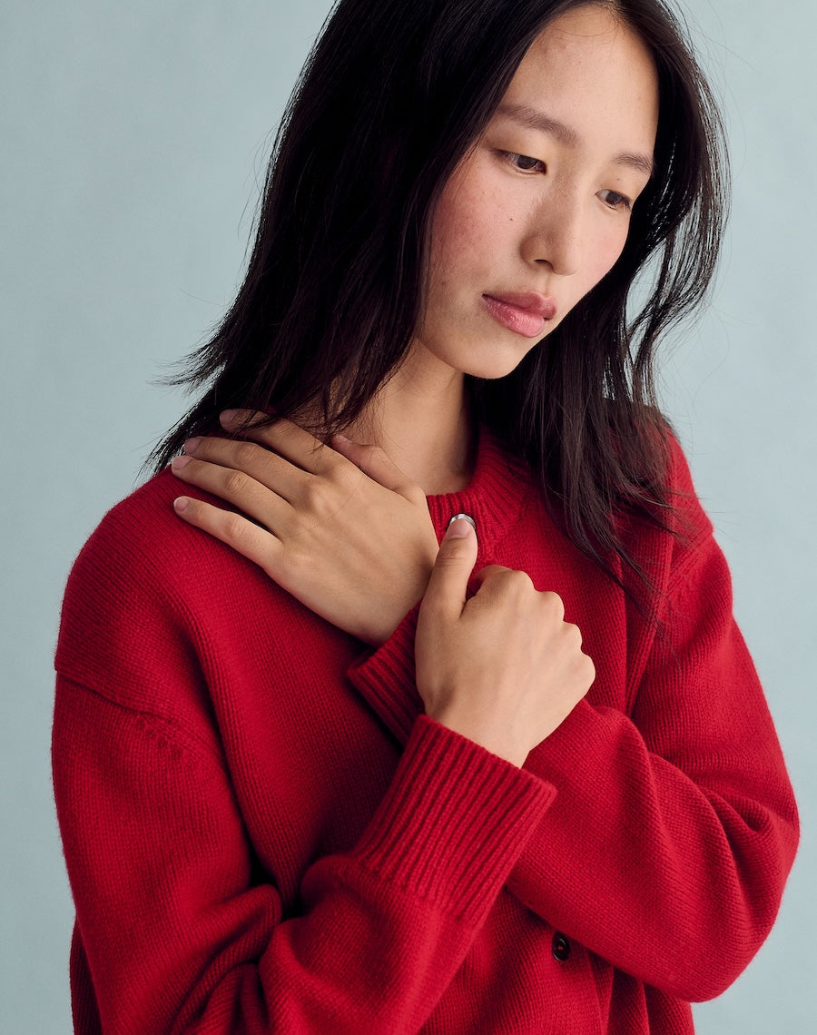 Woman wearing a red sweater against a light gray background