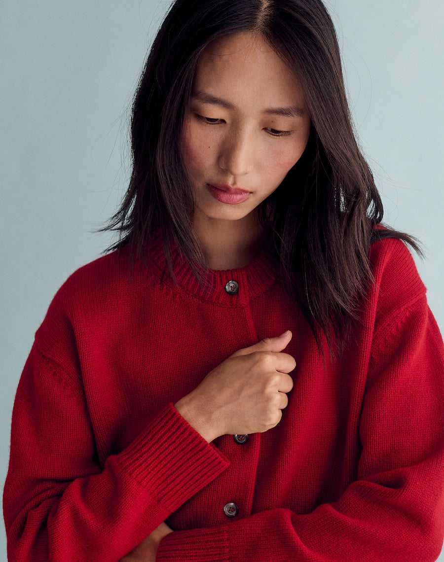 Woman wearing a red sweater against a gray background