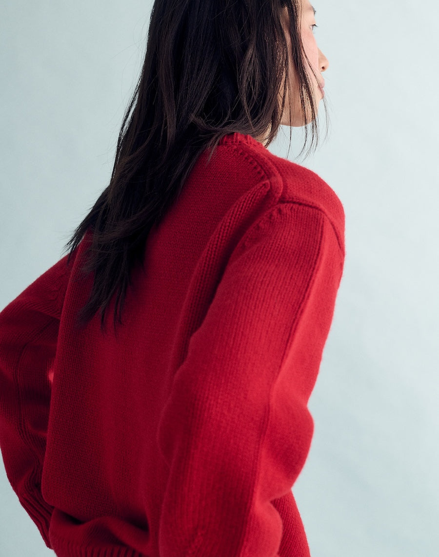 Person wearing a red sweater against a light gray background