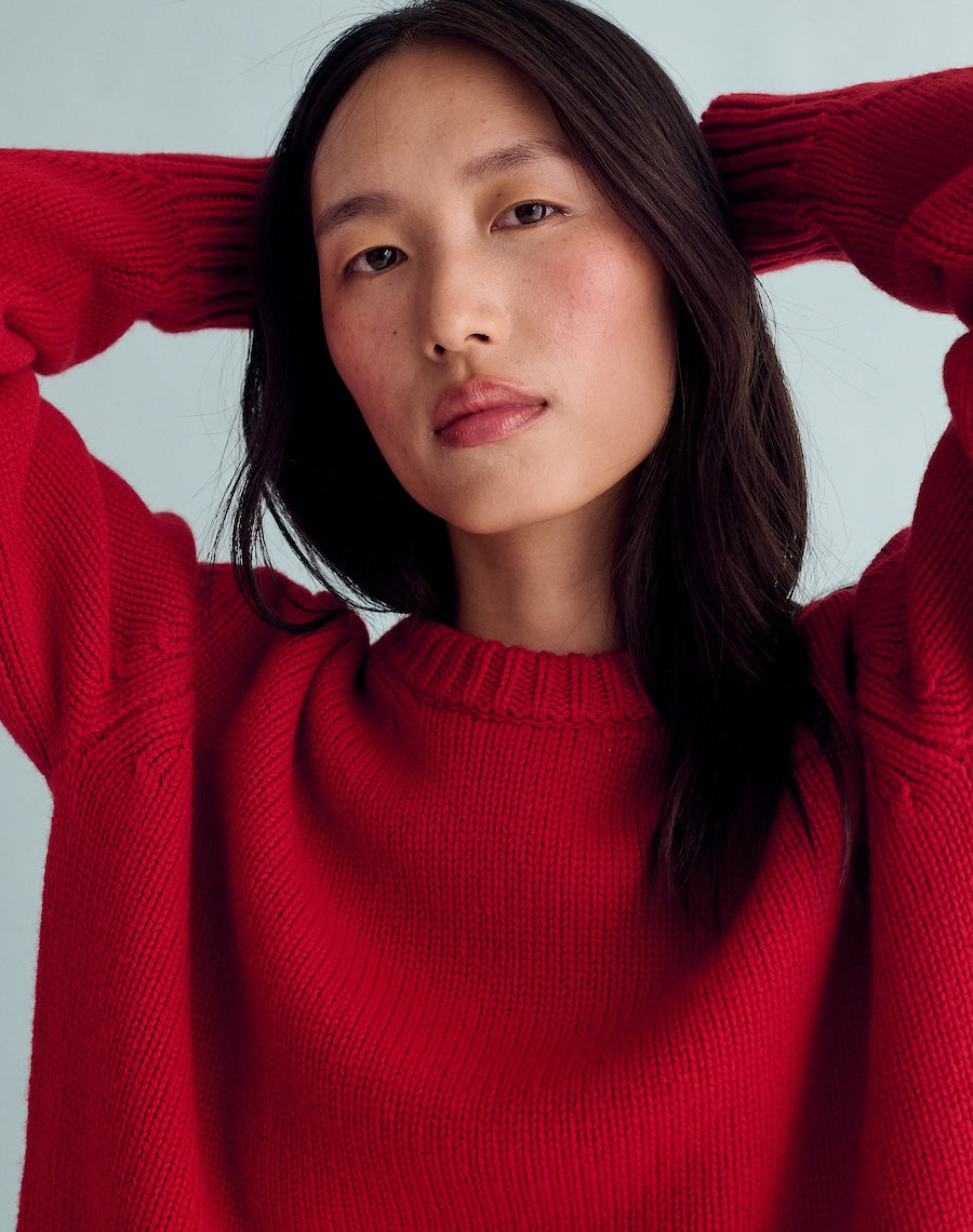 Woman wearing a red sweater against a light gray background