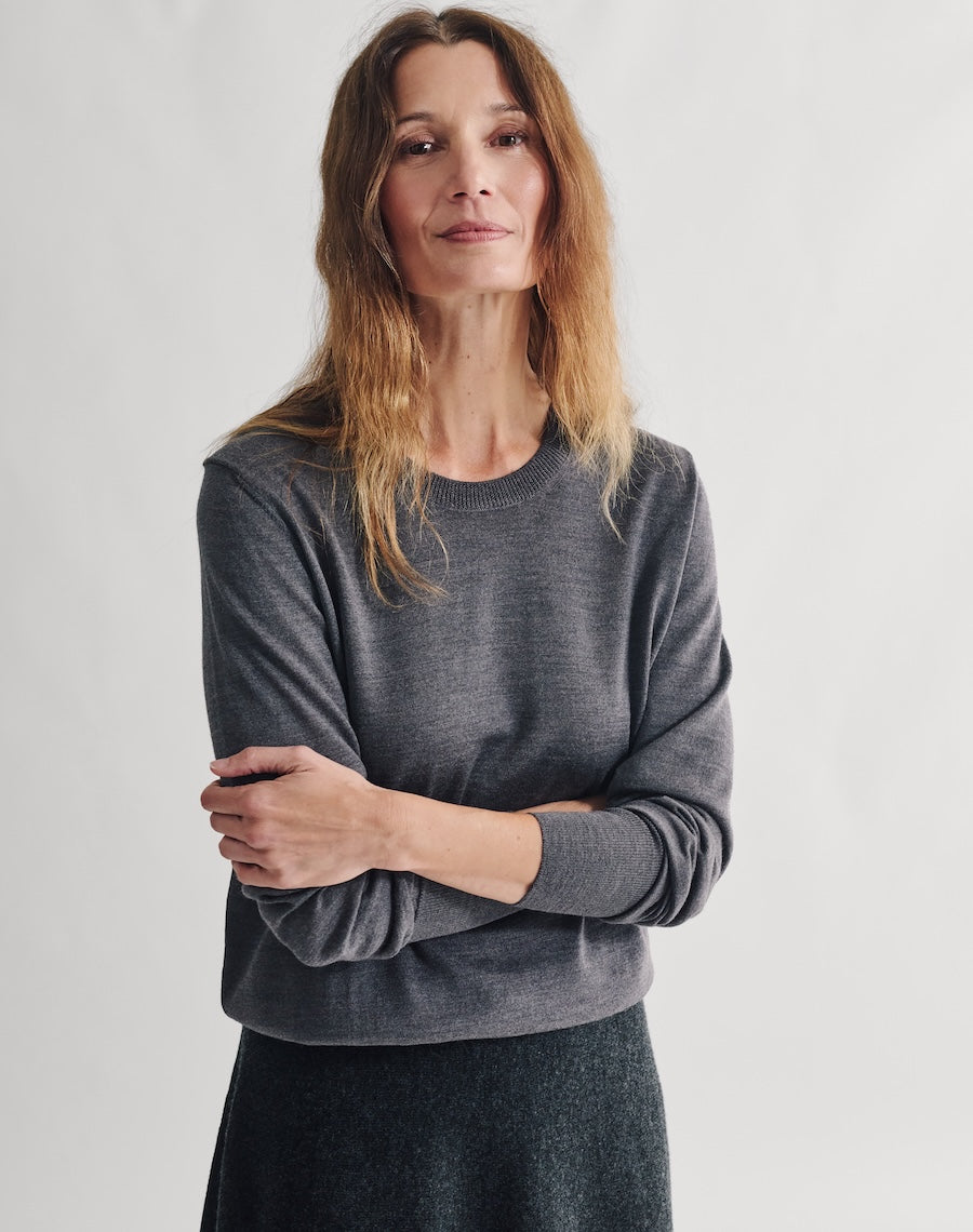 Woman wearing a gray sweater against a plain background