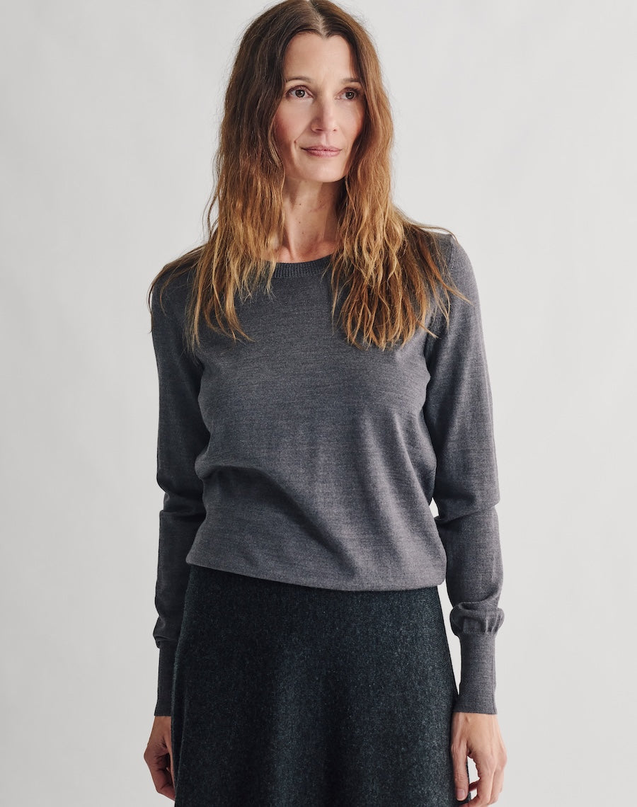 Woman wearing a gray sweater against a plain background