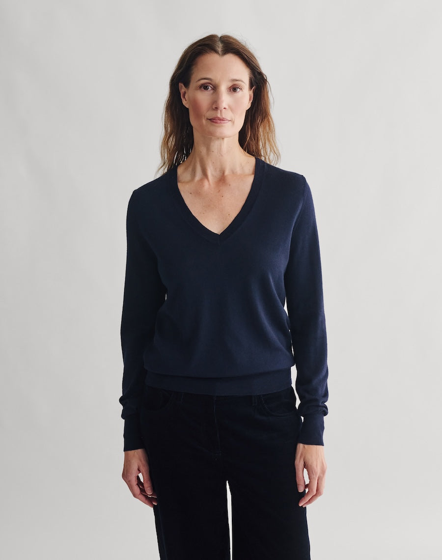 Woman wearing a navy blue sweater against a plain background