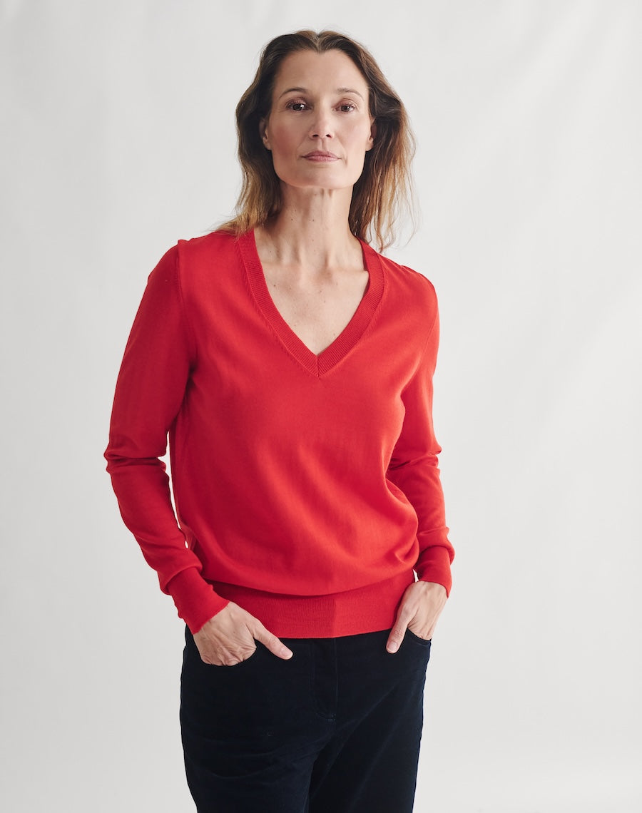 Woman wearing a red sweater against a white background