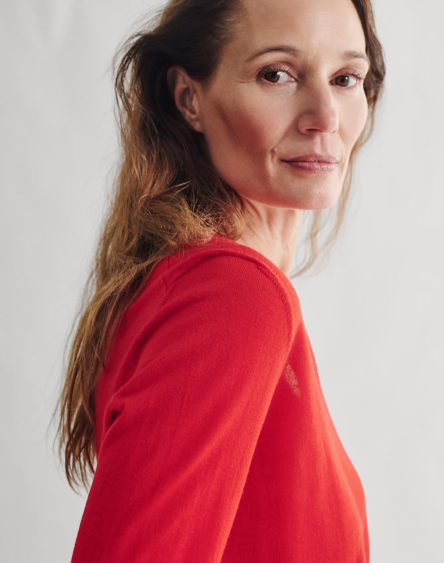 Woman wearing a red sweater against a white background