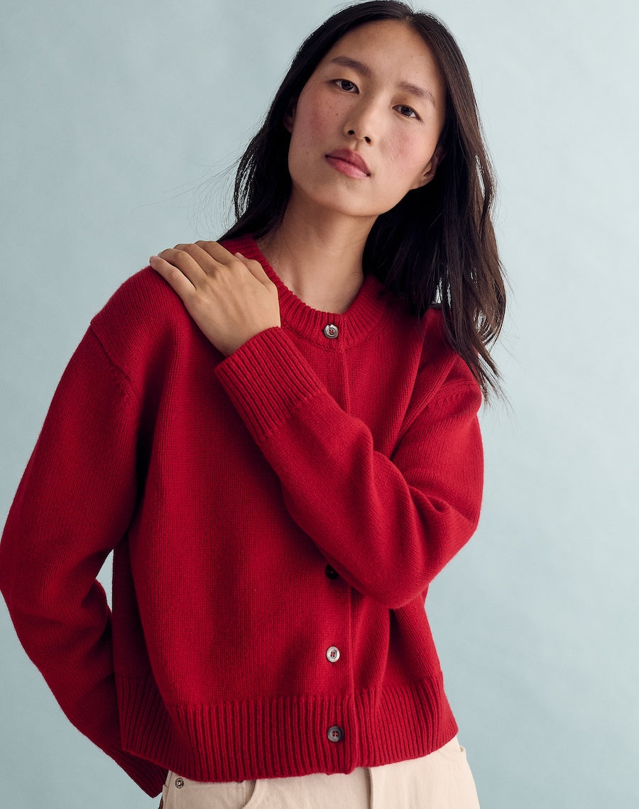Woman wearing a red sweater against a light gray background
