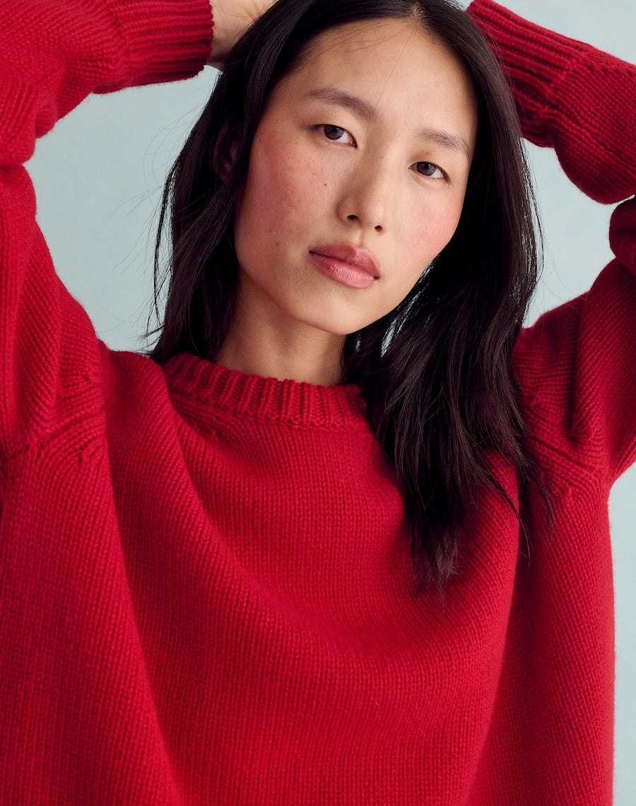 Person wearing a red sweater against a light gray background