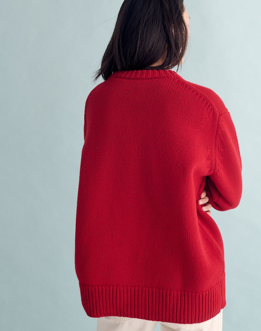 Person wearing a red sweater against a light gray background