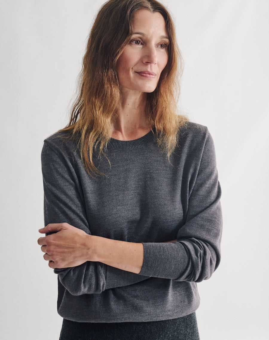 Woman wearing a gray sweater against a plain background