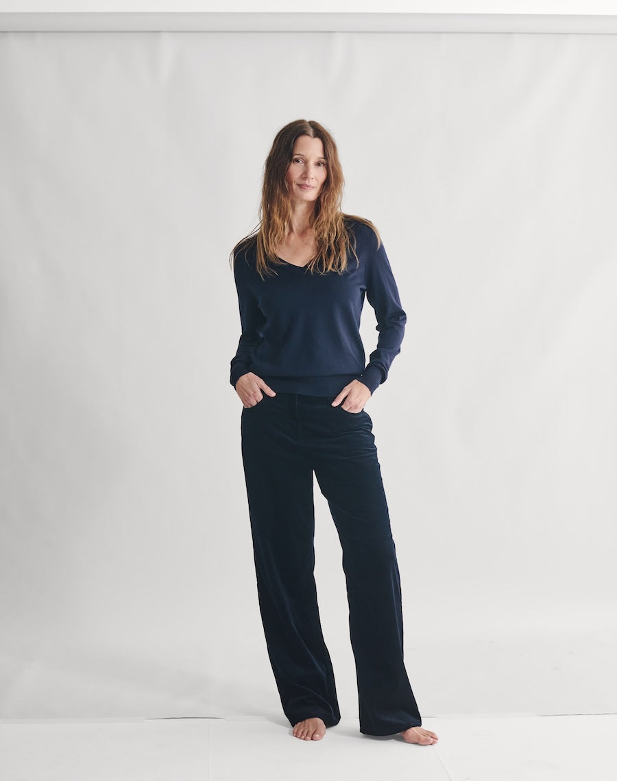 Woman wearing a navy blue outfit on a white background