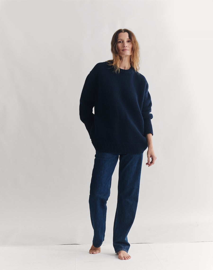Woman wearing a dark blue sweater and pants on a white background